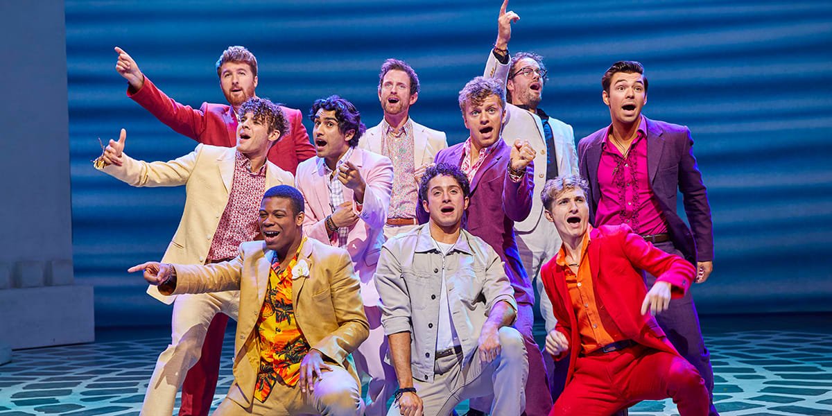 Front row LtoR Taylor Bradshaw as Eddie, Cameron Burt as Sky, Danny Nattrass as Pepper with the cast of MAMMA MIA_ Credit Brinkhoff & Mögenburg