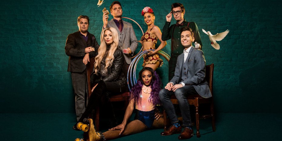 Magicians pose against a green background. One throws some cards in the air, one poses in the splits wearing roller skates and there is a dove flying next to a man sat in a chair