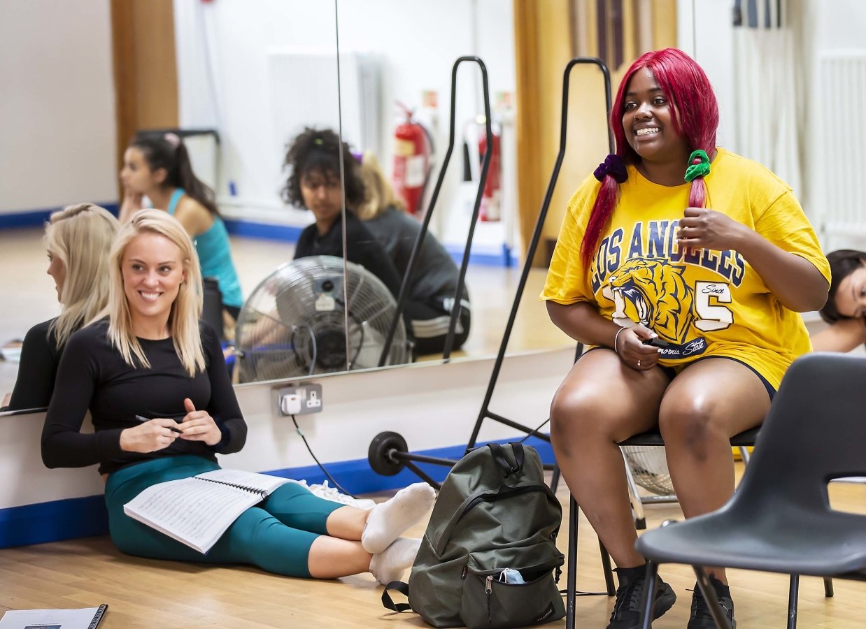 Aimee Hodnett sits on floor with script on knees and Maddison Swan sits on a chair