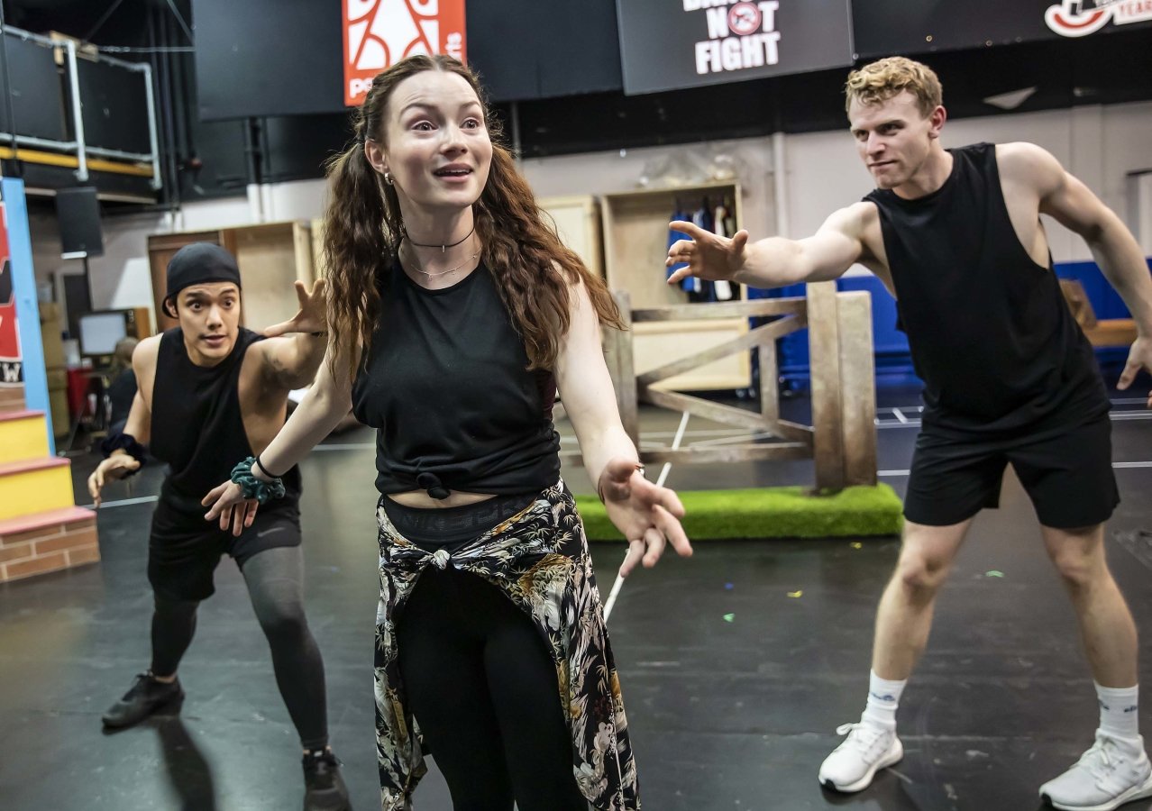 Christina Bennington stands centre of the image with two dancers standing beside her