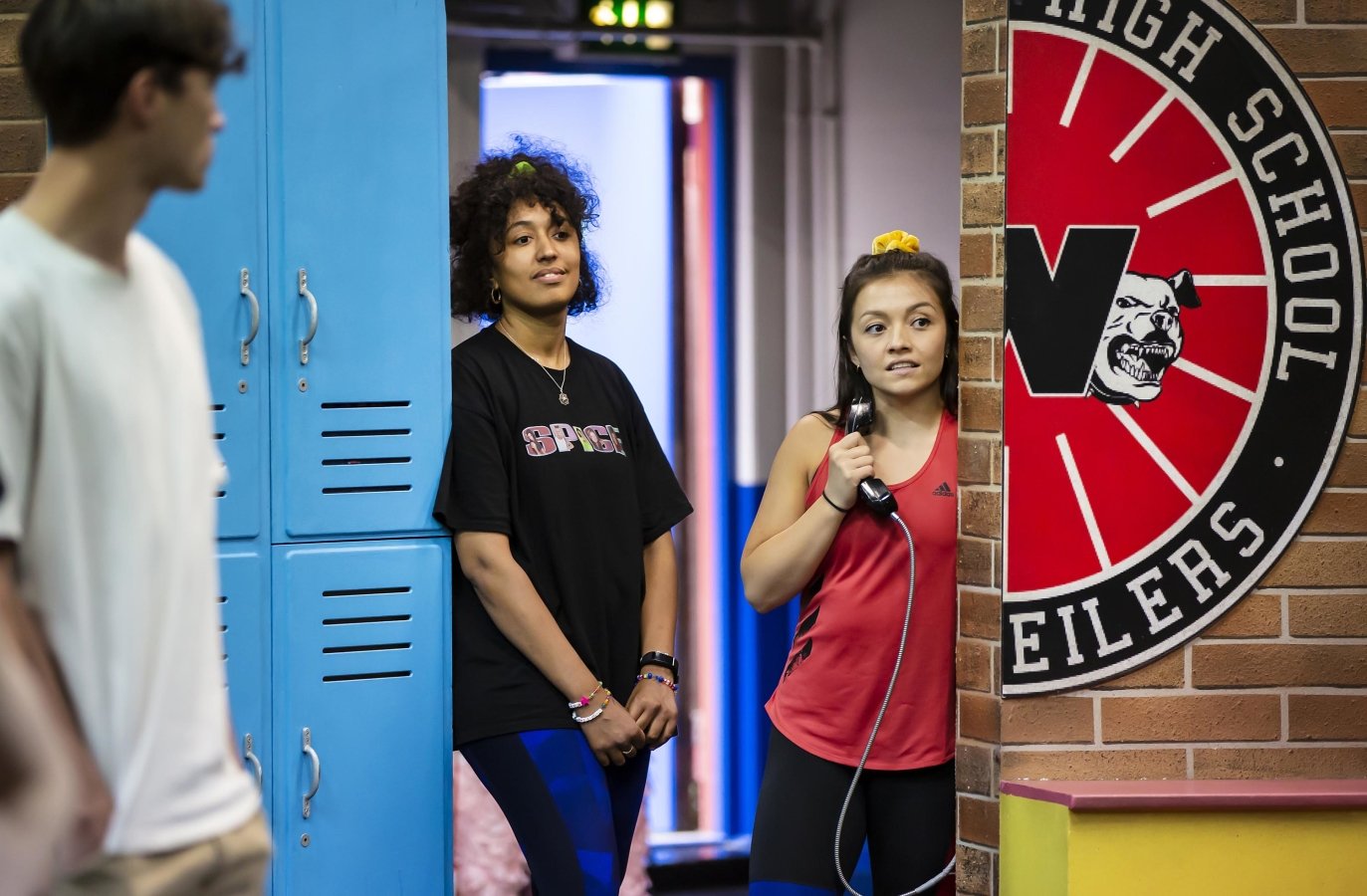 Bobbie Little and Frances Mayli McCann stand in a doorway by some school lockers