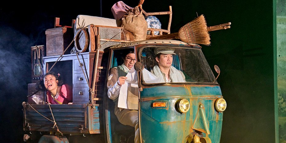 Mei (Mei Mac), Tatsuo (Dai Tabuchi) and Puppeteer (Yojiro Ichikawa) driving along in a Tuktuk piled high with belongings