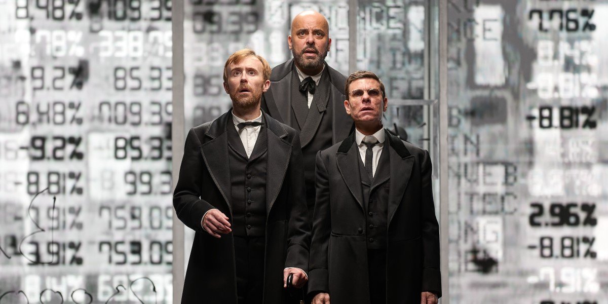 Three men in 19th-century attire stand in front of a digital stock market backdrop, appearing contemplative.